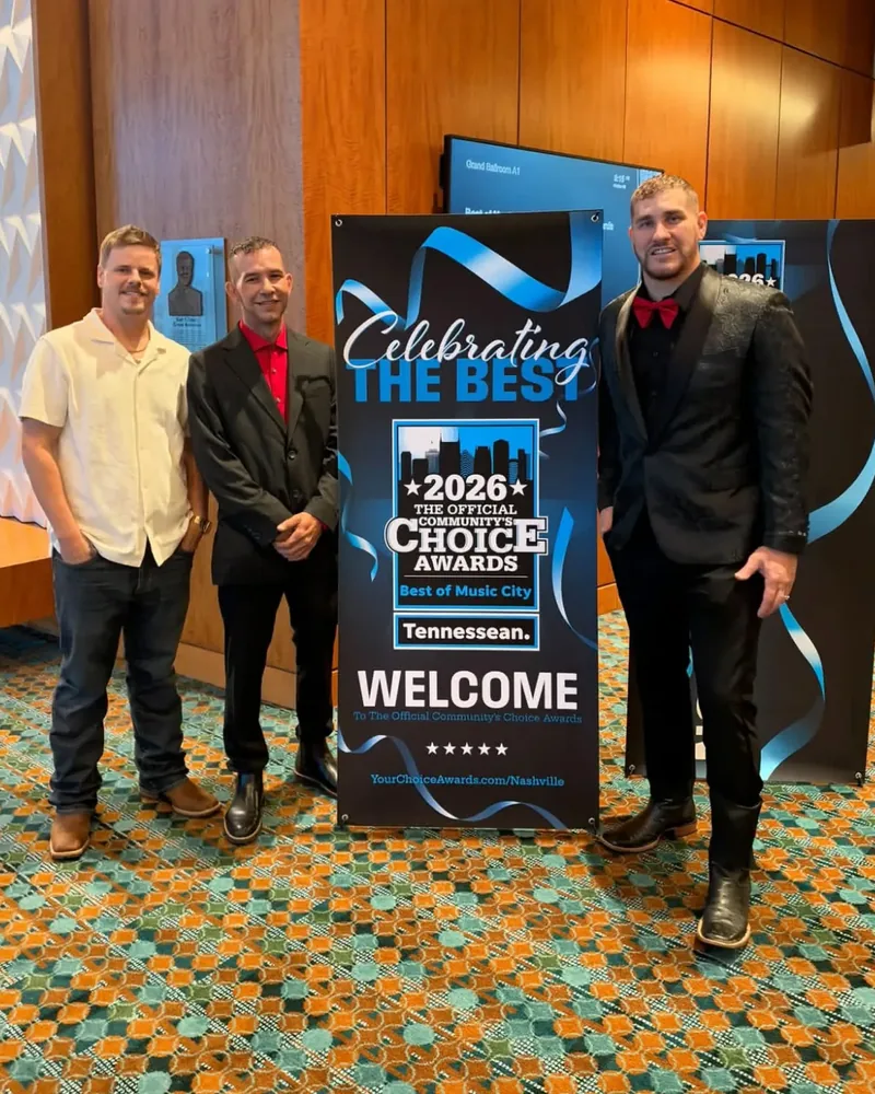 Three Tennessee Country Boys Moving representatives beside the 2026 Community’s Choice Awards, Best of Music City welcome sign.